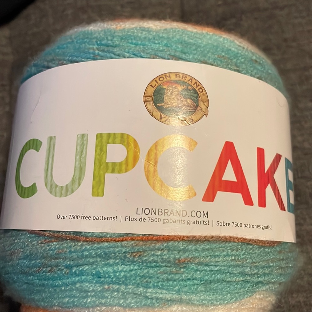 Lion Brand Cupcake Sea Breeze Yarn. Orange/peach, light green, white. 590 yards